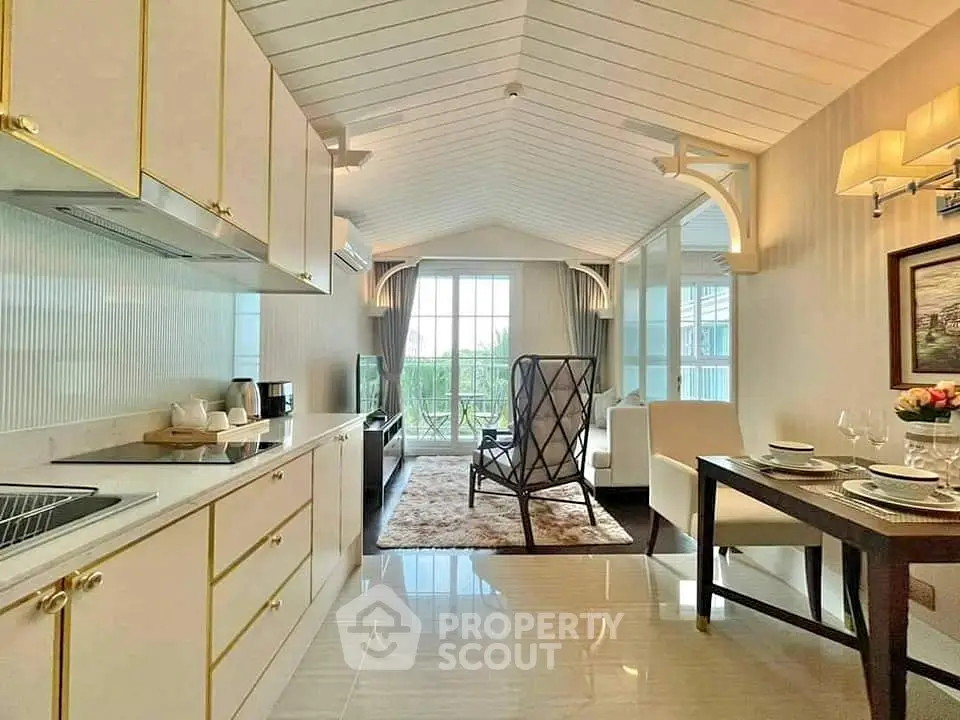 Elegant open-layout kitchen and living room with modern decor and large windows.