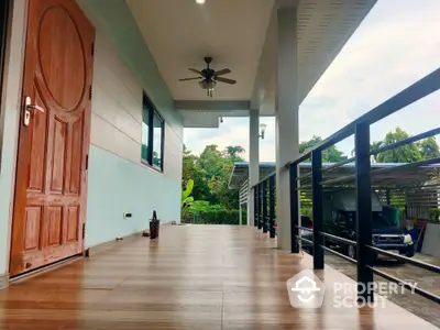 Spacious modern balcony with wooden flooring and ceiling fan, perfect for relaxation.