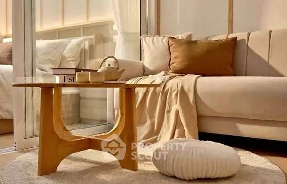 Cozy living room with modern beige sofa, wooden coffee table, and soft lighting.