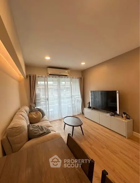 Cozy living room with modern decor and large TV, perfect for relaxation.