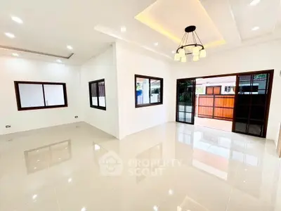 Spacious modern living room with elegant lighting and large windows, perfect for natural light.