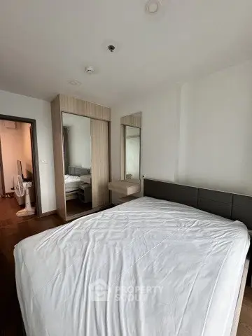 Modern bedroom with sleek design and ample natural light, featuring a comfortable bed and stylish wardrobe.