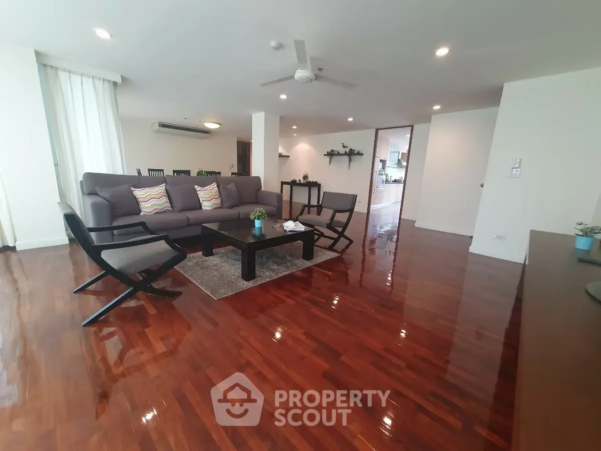 Spacious living room with polished wooden floors and modern furniture
