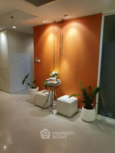 Modern interior with orange accent wall and stylish seating area
