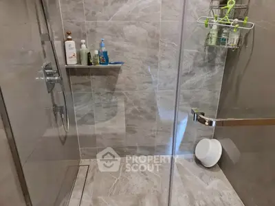 Modern bathroom with sleek marble tiles and glass shower enclosure