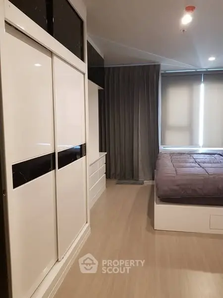 Modern bedroom with sleek wardrobe and cozy bed in stylish apartment.