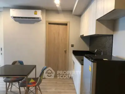 Modern kitchen with sleek cabinets and dining area in a stylish apartment.