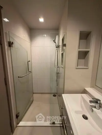 Modern bathroom with glass shower enclosure and sleek fixtures