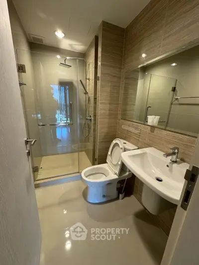Modern bathroom with glass shower and sleek fixtures in a contemporary apartment.