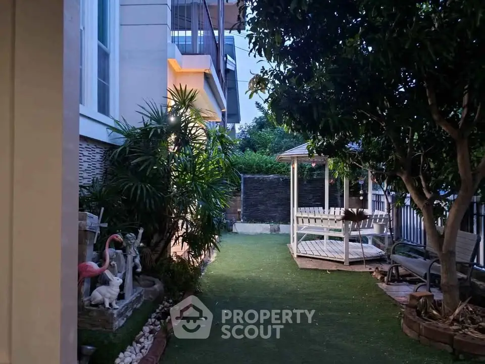 Charming garden with gazebo and lush greenery in a modern residential setting.