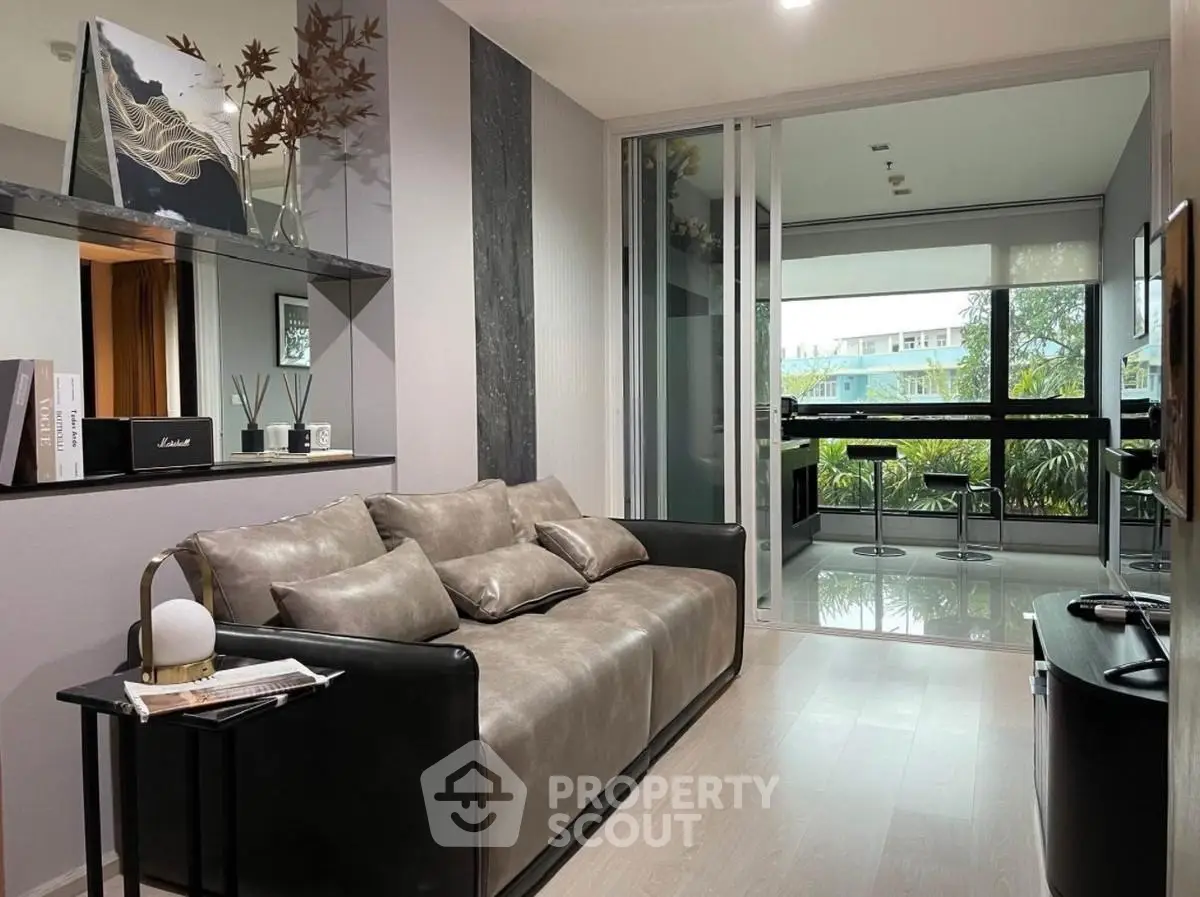 Modern living room with sleek design and large windows offering lush garden views.