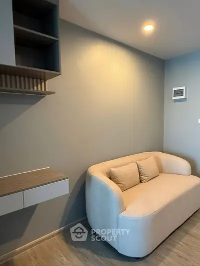 Cozy modern living room with stylish sofa and built-in shelving, perfect for relaxation.