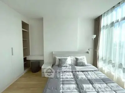 Bright and airy bedroom with modern minimalist design and large windows.