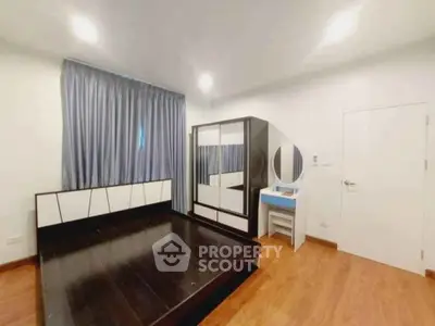 Spacious bedroom with modern furniture and wooden flooring