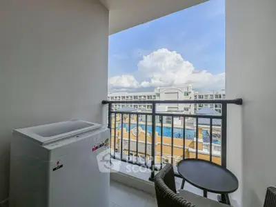 Charming balcony with washing machine and scenic view of pool and buildings.