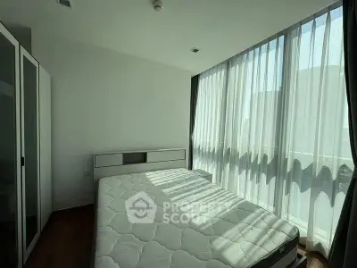 Bright bedroom with large windows and modern furnishings in a stylish apartment.