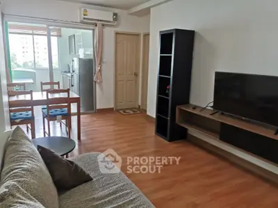 Modern living room with balcony access, featuring sleek furniture and hardwood flooring.
