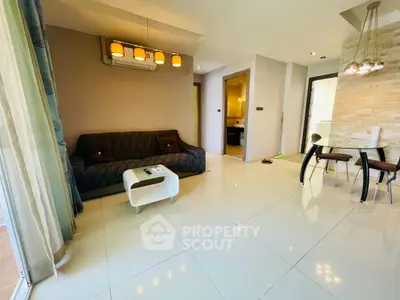 Spacious modern living room with elegant lighting and open dining area, perfect for entertaining guests.
