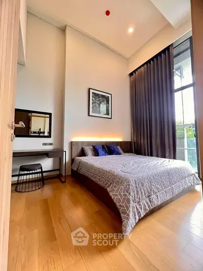 Modern bedroom with high ceiling and large window, featuring elegant decor and wooden flooring.