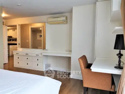 Spacious bedroom with study area and modern furnishings in a stylish apartment.