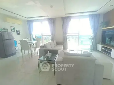 Spacious living room with modern furniture and large windows offering a scenic view.