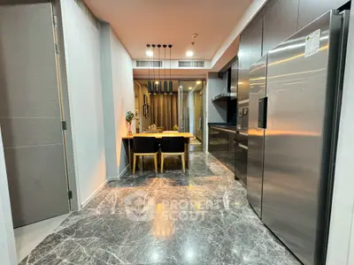 Modern kitchen with sleek appliances and elegant dining area, featuring marble flooring and contemporary lighting.
