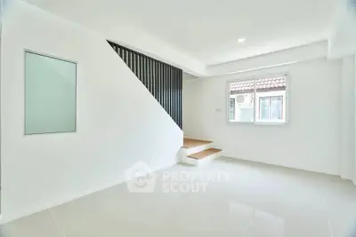Modern minimalist living room with sleek staircase and large window