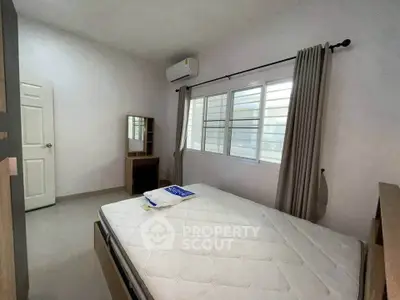 Spacious bedroom with natural light and modern furnishings in a cozy apartment.