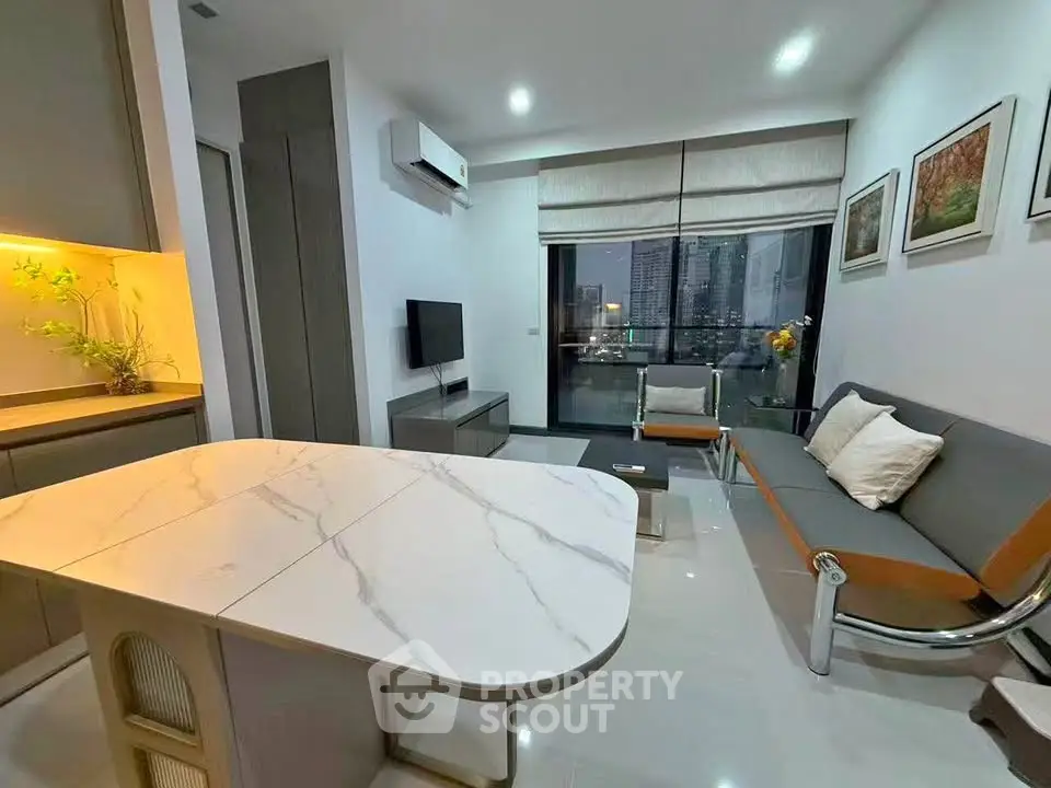 Modern living room with sleek furniture and city view, featuring a stylish open kitchen layout.