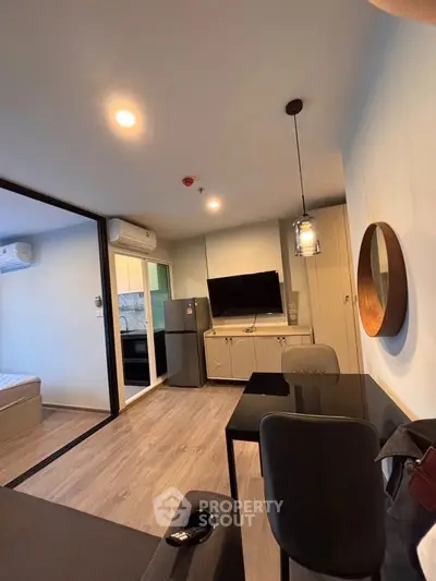 Modern apartment interior with open layout, featuring a sleek kitchen and cozy living area.