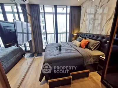 Luxurious bedroom with floor-to-ceiling windows and modern decor in high-rise apartment.