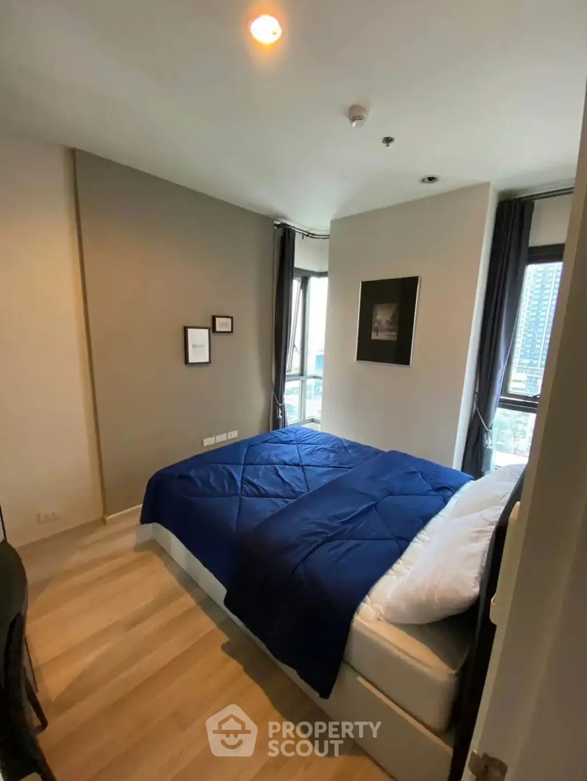 Cozy bedroom with modern decor and city view, perfect for urban living.