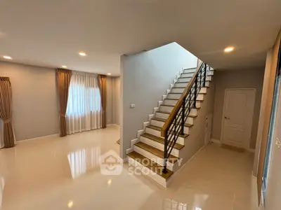Spacious modern interior with elegant staircase and natural light, perfect for stylish living.