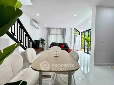 Modern living room with open layout, stylish furniture, and large windows for natural light.