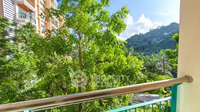 Stunning balcony view with lush greenery and mountain backdrop in modern apartment complex.