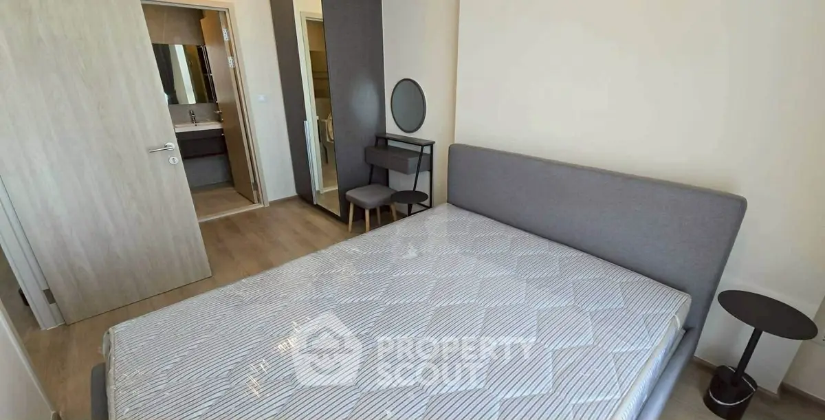 Modern bedroom with ensuite bathroom, featuring sleek furniture and neutral tones for a cozy ambiance.