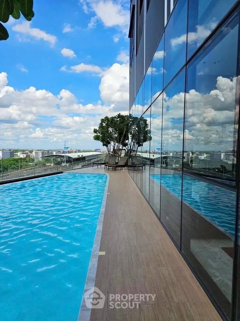 Stunning rooftop pool with panoramic city views and modern glass facade.