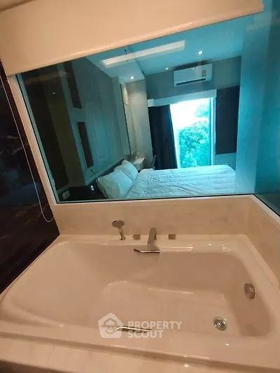 Luxurious bathroom with bathtub and view into modern bedroom