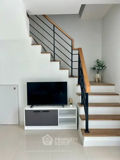 Modern staircase with sleek TV setup in stylish living area