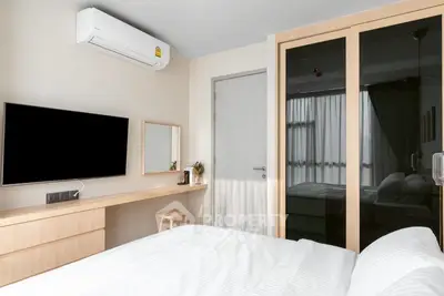 Modern bedroom with sleek design, featuring a wall-mounted TV, air conditioning, and stylish wooden furniture.