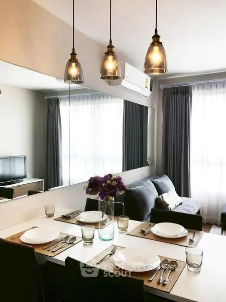 Modern dining area with elegant lighting and cozy seating in a stylish apartment.