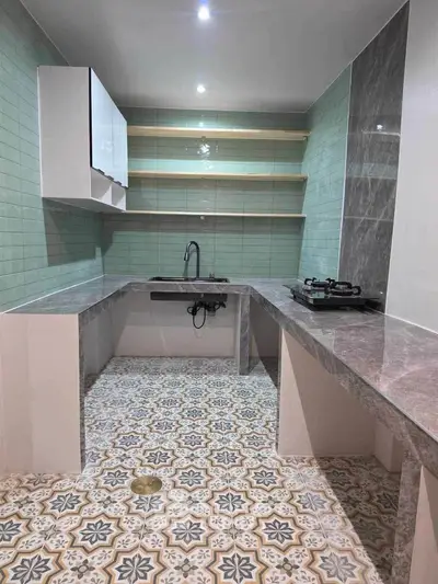 Charming kitchen with unique tile flooring and modern gas stove in a cozy open layout.