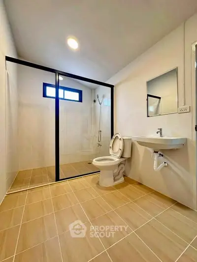 Modern bathroom with glass shower enclosure and sleek fixtures