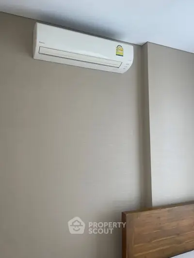 Modern bedroom with air conditioning unit and wooden headboard for comfort and style.