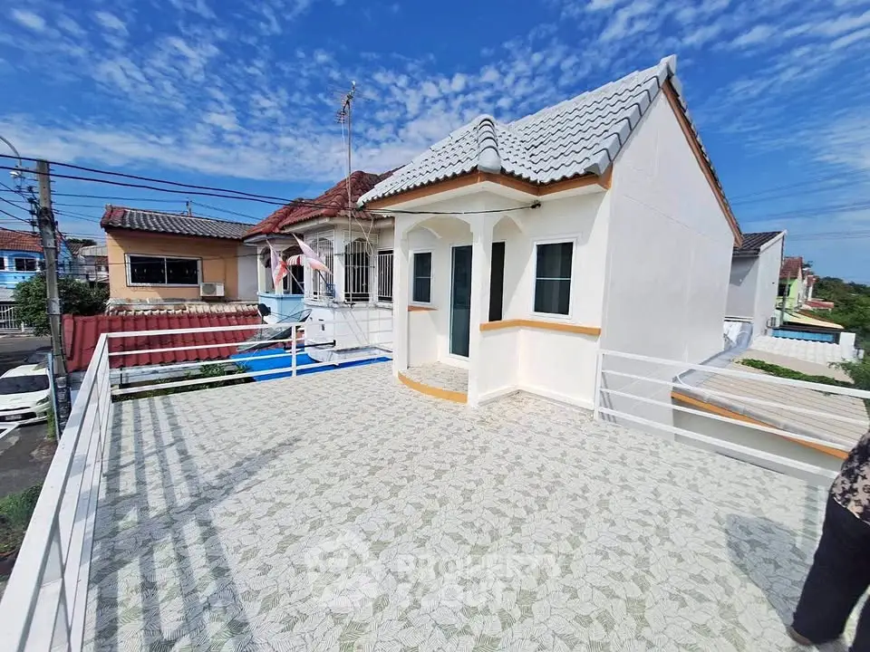 Charming rooftop terrace with tiled flooring and scenic neighborhood views under a clear blue sky.