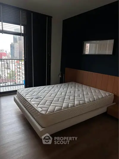 Spacious bedroom with city view and modern decor in urban apartment