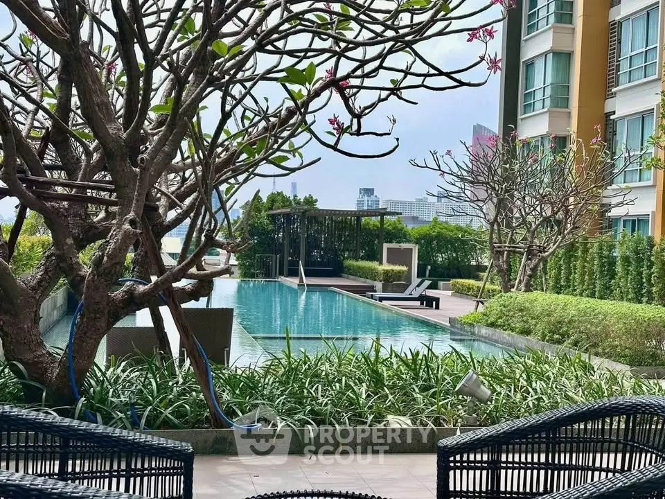 Luxurious apartment complex with stunning pool and lush garden view, perfect for relaxation and leisure.