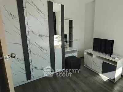 Modern bedroom with stylish marble accents and sleek TV stand