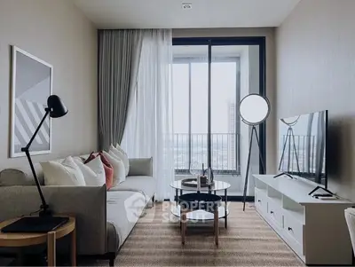 Modern living room with stylish decor and large window offering city view.
