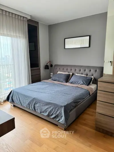 Modern bedroom with stylish decor and large window for natural light.